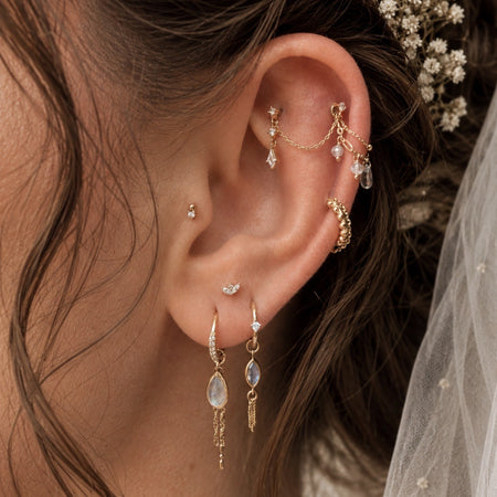 Bridal ear styling met verfijnde gouden piercingsieraden voor de bruid