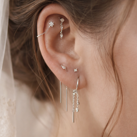 Close-up van bridal ear styling met witgouden piercingsieraden van All Perfectly Pierced