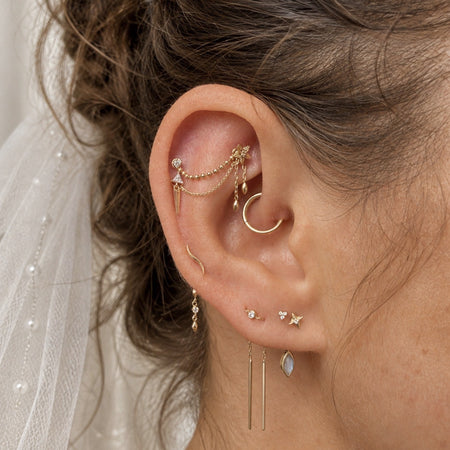 Luxe bridal ear styling met gouden en sprankelende piercingsieraden