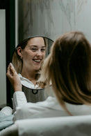 Vrouw bewondert haar nieuwe piercing bij All Perfectly Pierced, met een focus op kwaliteit en persoonlijke stijl.