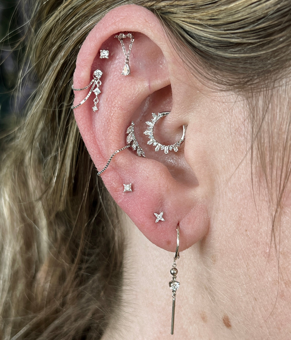 Stijlvol versierd oor met diverse piercings, inspiratie voor ear styling bij All Perfectly Pierced