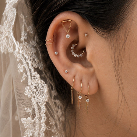 Persoonlijke bridal ear styling met elegante gouden piercings voor de trouwdag
