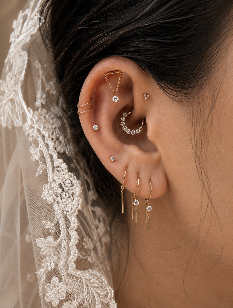 Persoonlijke bridal ear styling met elegante gouden piercings voor de trouwdag