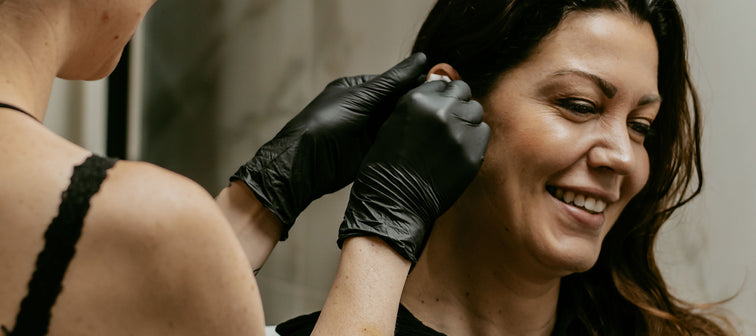 Reinigen van het oor voor de piercing bij All Perfectly Pierced, met zorg voor hygiëne en voorbereiding voor de plaatsing.