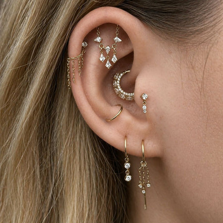 close up van luxe oorstyling met gouden piercings 