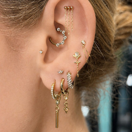 elegante oorstyling met subtiele gouden piercing sieraden in het oor