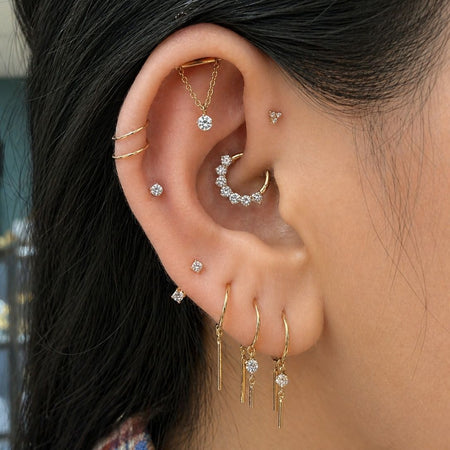 Oorstyling met daith piercing en verfijnde gouden piercingsieraden bij All Perfectly Pierced